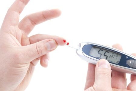 Dependent first type Diabetes patient measuring glucose level blood test using ultra mini glucometer and small drop of blood from finger and test strips isolated on a white background の写真素材