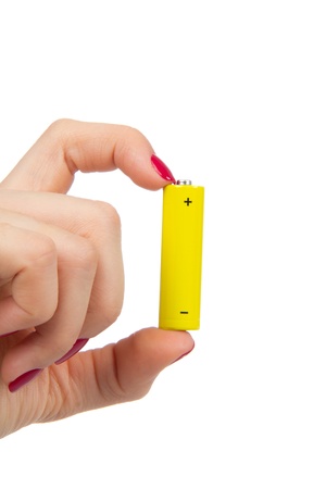 Woman hand hold yellow AA battery accumulator in hand between two fingers isolated on a white background の写真素材