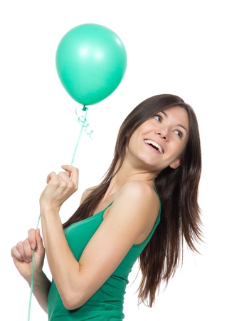 Young happy girl with green balloon as a present for birthday party smiling on a white backgroundの写真素材