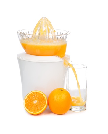 Preparing fresh orange juice squeezed with electric juicer on a white backgroundの写真素材