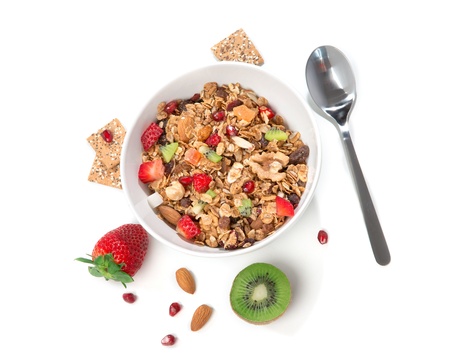 Muesli cereals bowl and spoon with almond, pine nuts, walnut,  raisins, oat and wheat flakes,...