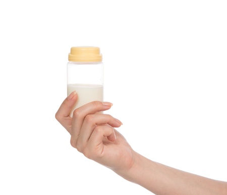 Child baby feeding bottle container with milk  in hand isolated on white backgroundの写真素材