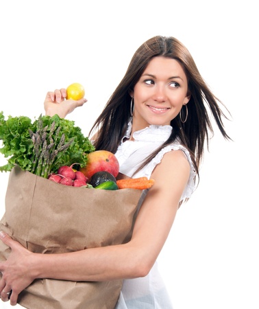 Young woman holding shopping bag with groceries vegetables and fruits isolated on white background. Healthy eating conceptの写真素材