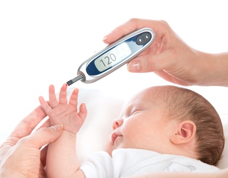 Measure child glucose level blood test diabetes patient baby using glucometer and small drop of blood from finger and test strips isolated on a white backgroundの写真素材