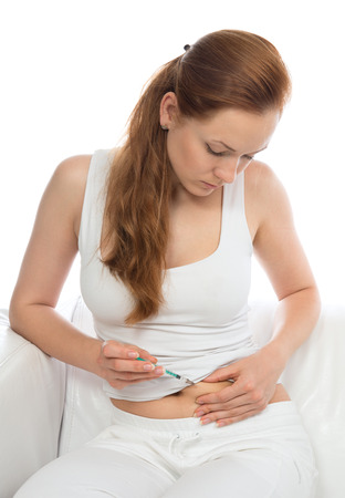 Diabetes woman patient make an abdomen subcutaneous insulin syringe injection vaccination shot isolated on white backgroundの写真素材
