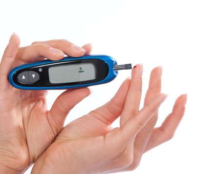 Diabetes patient measuring glucose level blood test isolated on a white backgroundの写真素材