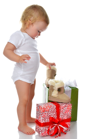 infant child baby toddler kid preparing presents gifts and small winter shoes boots for celebration isolated on a white background Christmas new year conceptの写真素材