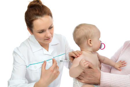 Doctors hand with syringe vaccinating child baby flu injection shot isolated on a white backgroundの写真素材