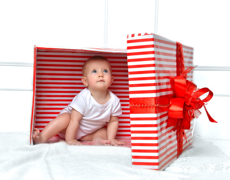Infant child baby toddler kid sitting in presents gift for celebration for birthday. Christmas new year concept.の写真素材