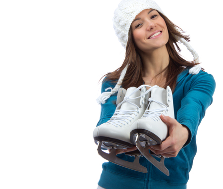 Young girl showing giving ice skates for winter ice skating sport activity in white hat happy smiling isolated on a white backgroundの写真素材