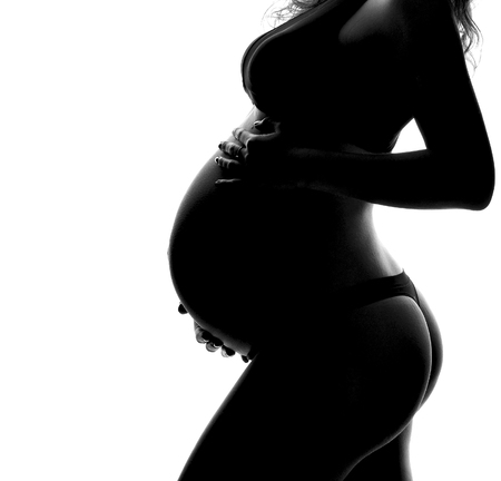 Pregnant woman silhouette on a white background with copy text spaceの写真素材