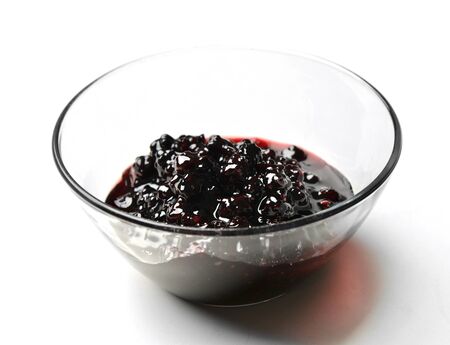 Sweet blackberry jam in the transparent glass bowl on a white backgroundの写真素材
