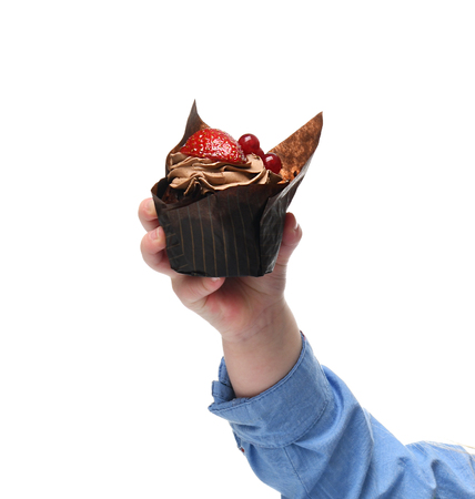 Baby hand hold and give little muffin chocolate cake with fresh strawberry fruit isolated on white backgroundの写真素材