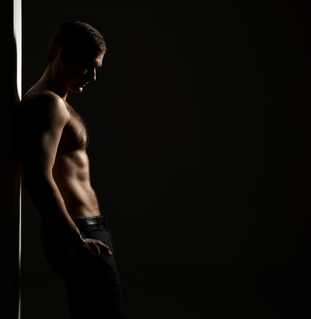 Closeup portrait of sexy handsome topless male model on dark black backgroundの写真素材