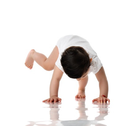 9 month infant child baby  girl toddler crawling isolated on a white backgroundの写真素材