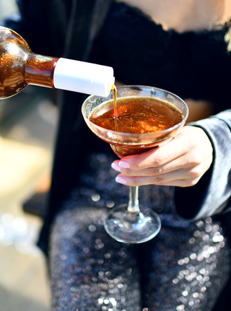 Beautiful fashion woman drink gold glitter martini cosmopolitan cocktail in restaurant cafeの写真素材