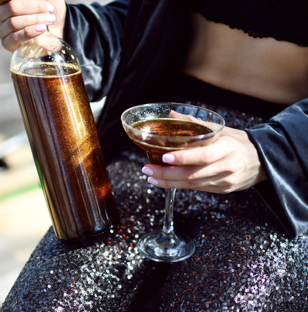 Beautiful fashion woman drink gold glitter martini cosmopolitan cocktail in restaurant cafeの写真素材