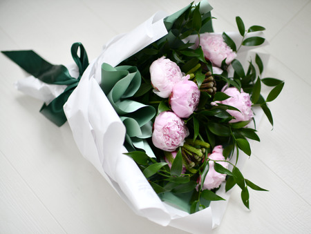 Bouquet of pink peony flowers with green leafs on grey backgroundの写真素材