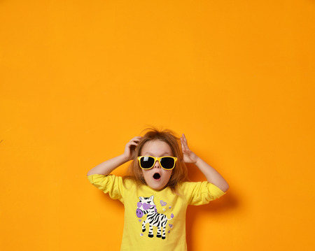 Young baby girl child kid surprised screaming in yellow zebra shirt and sunglasses with text space