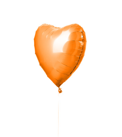 Single big  orange heart balloon object for birthday party isolated on a white backgroundの写真素材
