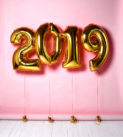 2019 Christmas inflatable gold numbers balloons on pink background for new year celebrationの写真素材