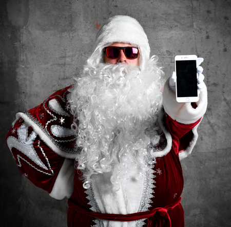 Santa Claus show blank screen with text space of mobile cellphone. New year and Merry Christmas and happy holidays conceptの写真素材