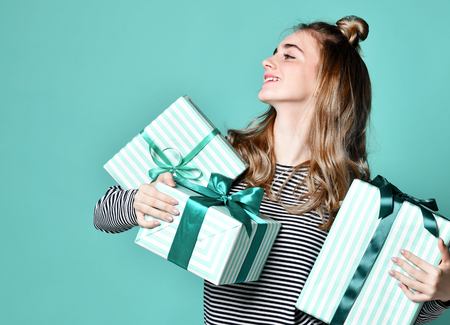 Portrait of a happy young woman hold blue present gift boxes looking at the corner on mint