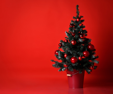 Christmas tree decorated with red patchwork ornament balls presents for new year 2019 on dark red backgroundの写真素材