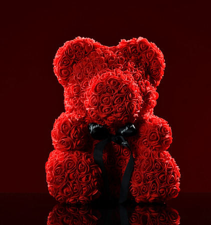 Red bear of roses present gift for valentines day or woman birthday on dark redの写真素材