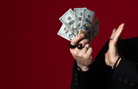 Business man hand holding American dollars banknotes with no sign on red