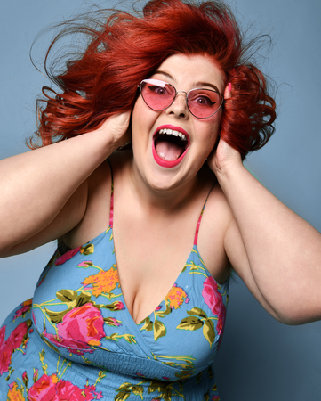 Surprised overweight fat woman happy laughing smiling screaming having good time crazy shopping sale on popular blue mintの写真素材