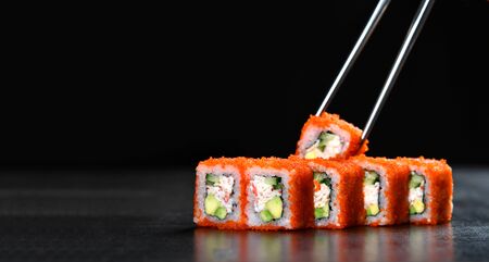 Japanese and Asian cuisine sushi set rolls with fresh ingredients over black background with text copy spaceの写真素材