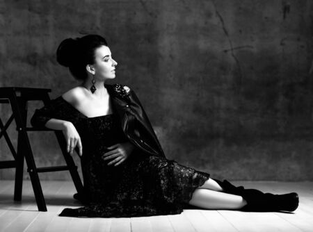 Portrait of young beautiful happy pregnant woman in black lace dress, leather jacket and boots...