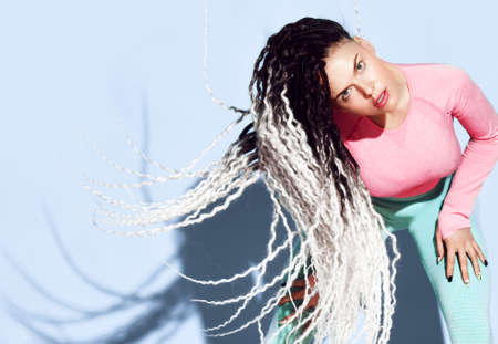 Portrait of young athletic girl with blond dreadlocks hairstyle in sexy tight sportswearの写真素材