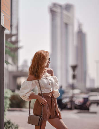 Tourist blonde woman in shorts and top is enjoying sightseeing tour during vacation in Dubai in United Arab Emiratesの写真素材