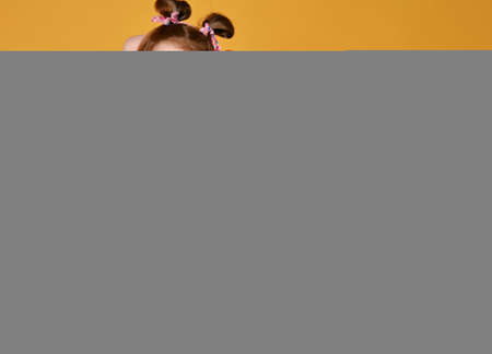 Screaming kid girl in colorful clothes dances holding two sensory rainbow color toys round and...