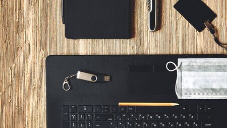 Laptop, notebook, protective mask and pocket knife on table. Flashcard and pencil, flat lay.