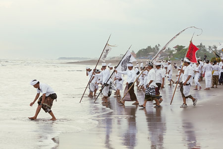 BALI, INDONESIA - MARCH 28: Balinese men do the ablution in the ocean after a procession from the center of the island to the ocean coast for the annual ceremony of purification Melasti on the Berawa beach, Bali on March 28, 2014のeditorial素材