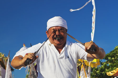 BALI INDONESIA  MARCH 18: Face portrait of an unidentified man in trance pricking himself by Kris  traditional Balinese dagger during ritual fighting dance on Melasti  religious ceremony of Balinese people Bali on 18 March 2015のeditorial素材
