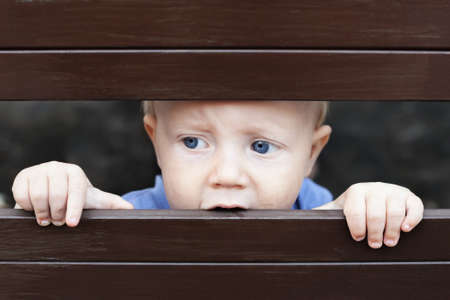 Portrait of abandoned by parents little baby boy with staring blue eyes, sad and lonely face...