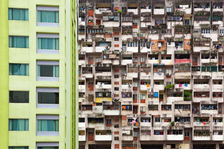 Geometrical pattern of multistory apartment house with group of windows and tenant lumber on balconies. Asian cities street background. Cheap accommodation, social problems in overcrowded countries.の写真素材