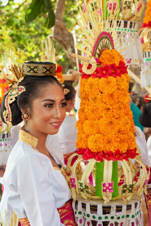 DENPASAR, BALI ISLAND, INDONESIA - JUNE 11, 2016: Beautiful woman in traditional costume. Group of Balinese people with religious offering for hindu ceremony on parade at art and culture festival.のeditorial素材