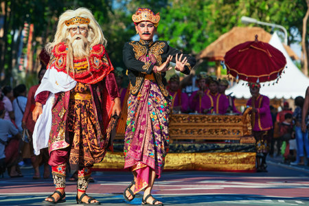 DENPASAR, BALI ISLAND, INDONESIA - JUNE 11, 2016: Group of Balinese people. Beautiful dancer men in traditional costumes and masks dance on street parade at art and culture festival.のeditorial素材