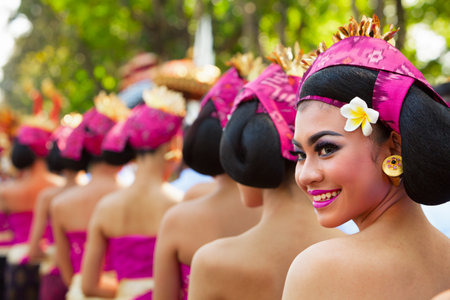 Denpasar, Bali island, Indonesia - June 10, 2017:  Group of beautiful women in traditional Balinese costumes carry religious offering for hindu ceremony on street parade at art and culture festival.のeditorial素材