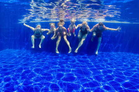 Happy family in swimming pool. Smiling mother, children and grandparents swim, dive in pool with fun - jump deep down underwater. Healthy lifestyle, people water sport activity on holidays with kids