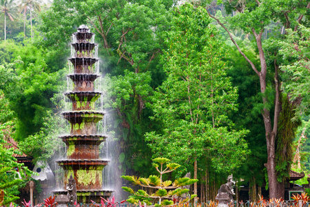 Cascade fountain in ancient water palace and tropical park Tirta Gangga with natural pools, fish ponds with statues. Culture, traditional arts of Bali island, popular travel destination in Indonesia.のeditorial素材