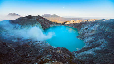 Sunrise panoramic view of Kawah Ijen volcano crater, largest in world sulphur acidic lake with hot steam, poisonous fume. Popular travel destination, adventure hike tour in East Java, Indonesiaの写真素材