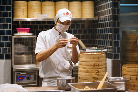 Johor, Malaysia - March 22, 2018: Asian chefs cooking traditional Chinese food in Taiwanese dumplings restaurant. Men cook and make fresh dough of steamed buns known as xiao long bao, mantou, dim sum.のeditorial素材
