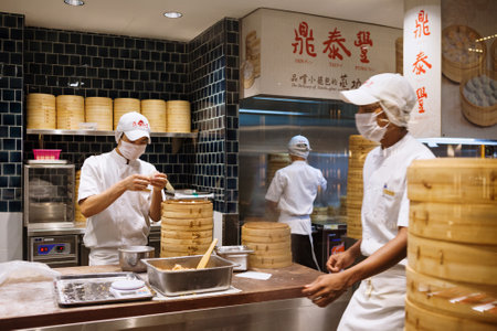 Johor, Malaysia - March 22, 2018: Asian chefs cooking traditional Chinese food in Taiwanese dumplings restaurant. Men cook and make fresh dough of steamed buns known as xiao long bao, mantou, dim sum.のeditorial素材