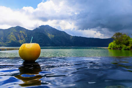 Natural hot spring spa beside Batur volcano. Hot water flowing to infinity pool with beautiful lake...